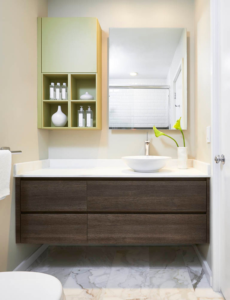This is an example of a small contemporary bathroom in Detroit with a vessel sink, flat-panel cabinets, dark wood cabinets, engineered quartz benchtops, beige walls and marble floors.