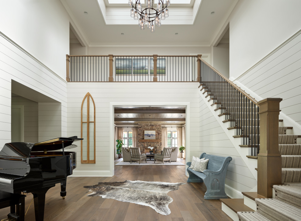 Design ideas for a country foyer in Chicago with white walls, medium hardwood floors and planked wall panelling.
