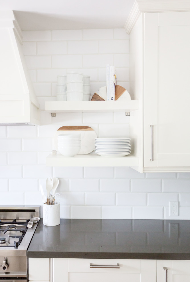 Large transitional u-shaped light wood floor and brown floor eat-in kitchen photo in Phoenix with a farmhouse sink, recessed-panel cabinets, white cabinets, quartz countertops, white backsplash, subway tile backsplash, stainless steel appliances, an island and white countertops