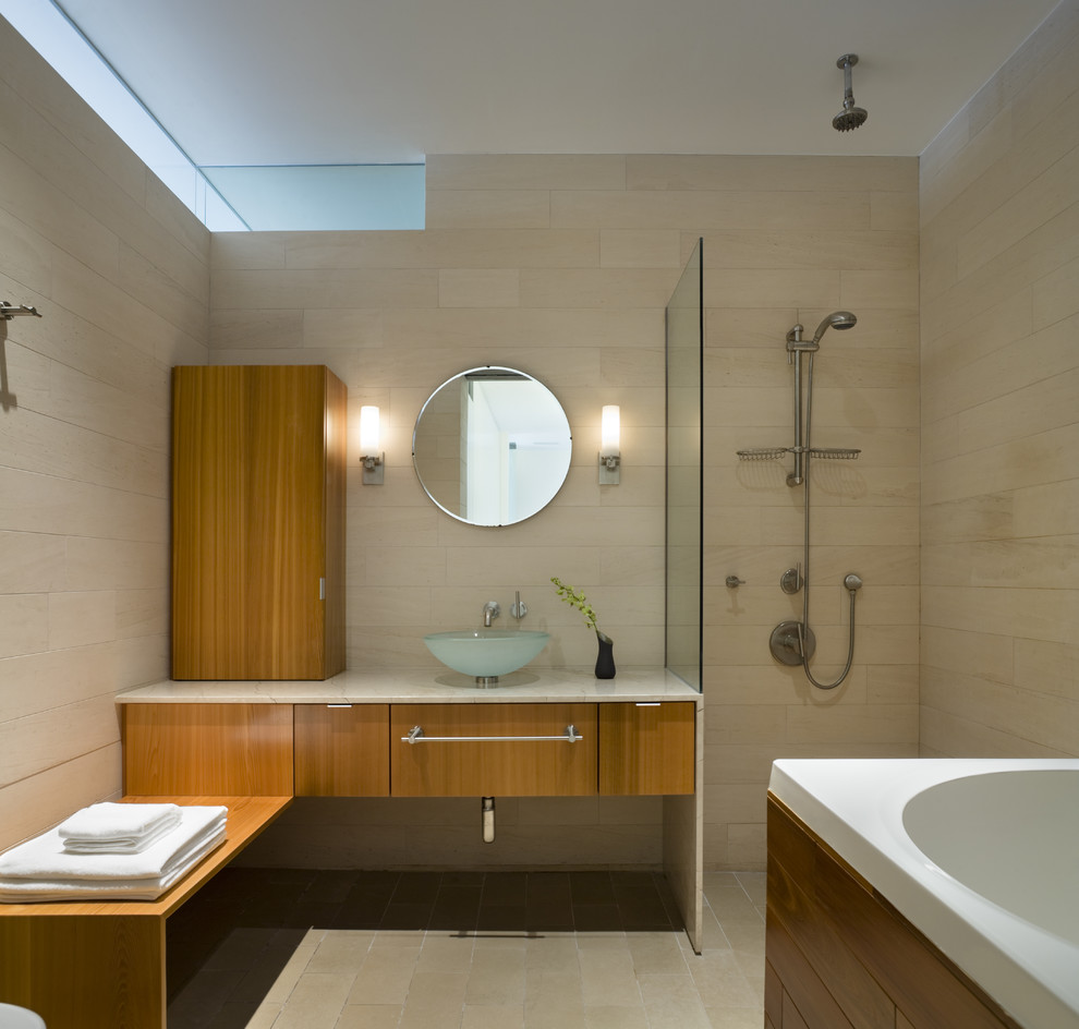 This is an example of a modern bathroom in New York with an open shower, stone tile, a vessel sink and an open shower.