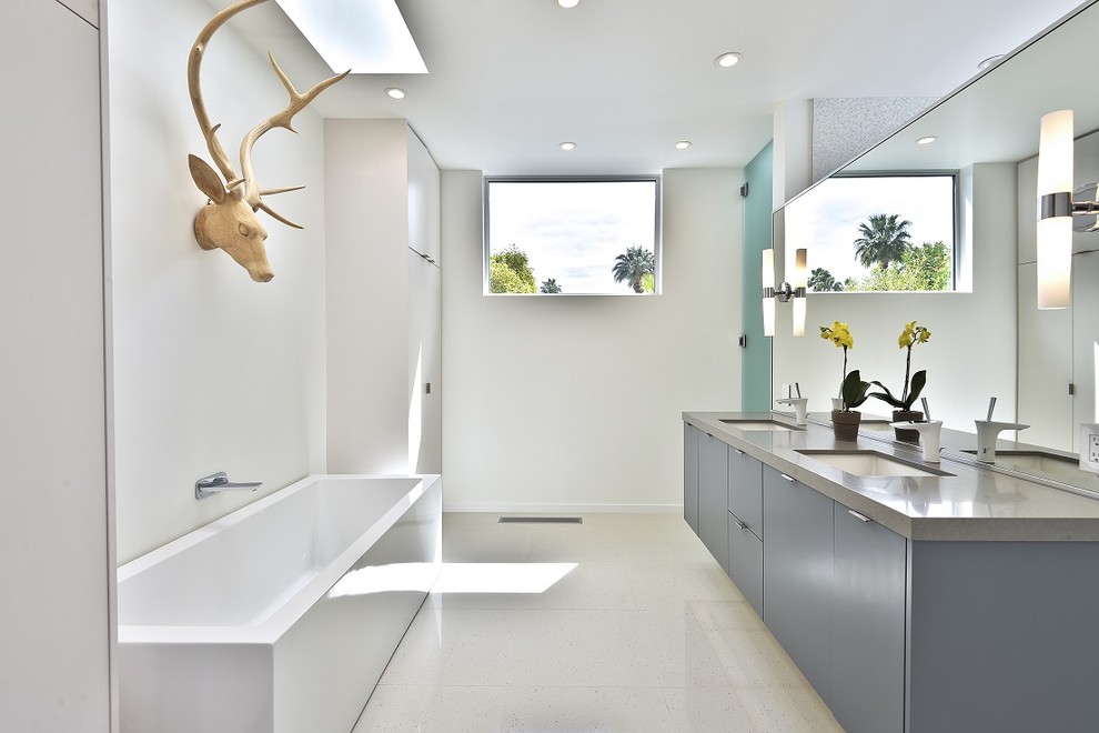 This is an example of a contemporary bathroom in Seattle with an undermount sink, flat-panel cabinets, grey cabinets, a freestanding tub, white walls and grey benchtops.
