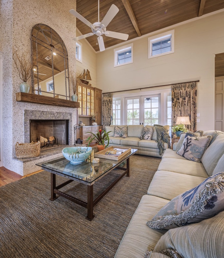 Beach style open concept living room in Charlotte with beige walls, medium hardwood floors and a standard fireplace.