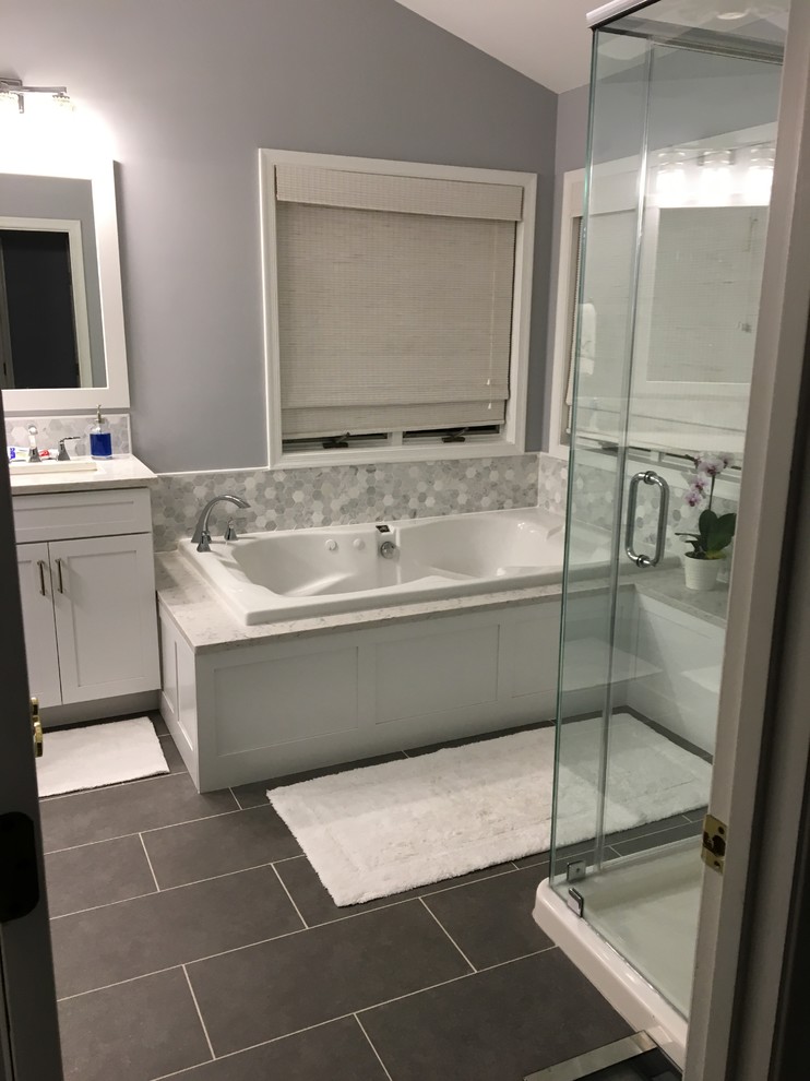 Example of a large transitional master gray tile, white tile and porcelain tile porcelain tile and gray floor drop-in bathtub design in Baltimore with shaker cabinets, white cabinets, purple walls, an undermount sink, quartz countertops, a hinged shower door and white countertops