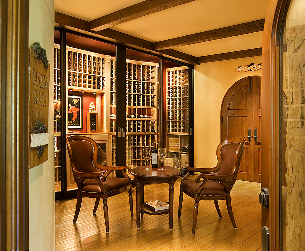 Design ideas for a mid-sized mediterranean wine cellar in Los Angeles with light hardwood floors and storage racks.
