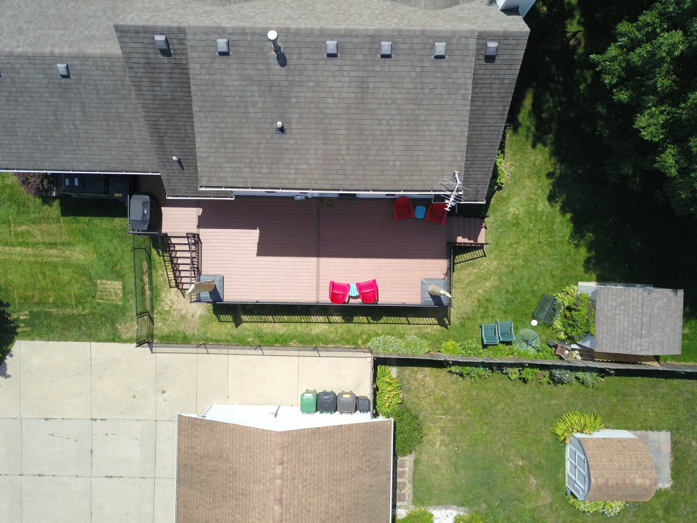 Example of a large backyard ground level metal railing deck design with no cover