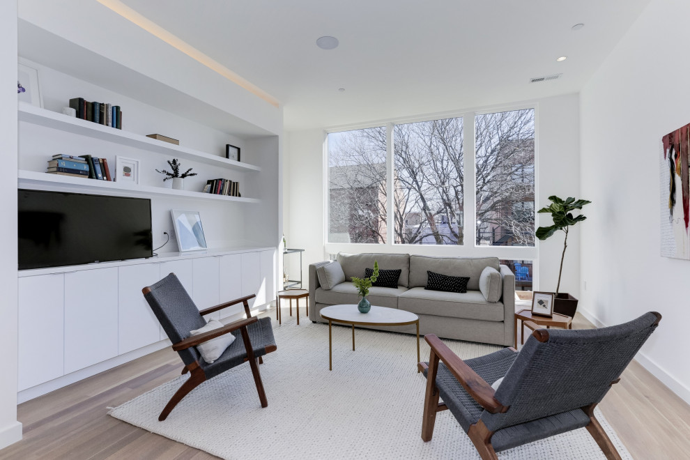 Mid-sized modern open concept family room in DC Metro with white walls, vinyl floors, a freestanding tv, beige floor and no fireplace.