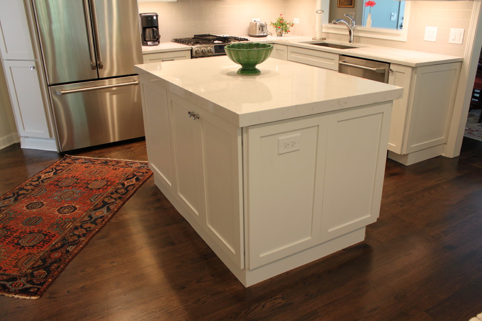 Mid-sized transitional l-shaped dark wood floor and brown floor enclosed kitchen photo in Chicago with an undermount sink, recessed-panel cabinets, white cabinets, quartzite countertops, white backsplash, subway tile backsplash, stainless steel appliances and an island