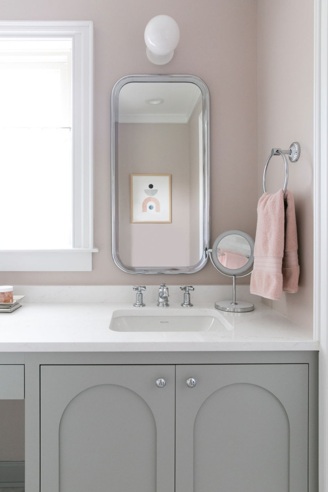 Photo of a mid-sized transitional kids bathroom in New York with recessed-panel cabinets, grey cabinets, an alcove tub, a shower/bathtub combo, a two-piece toilet, white tile, ceramic tile, pink walls, marble floors, an undermount sink, engineered quartz benchtops, multi-coloured floor, a hinged shower door, white benchtops, a double vanity and a built-in vanity.