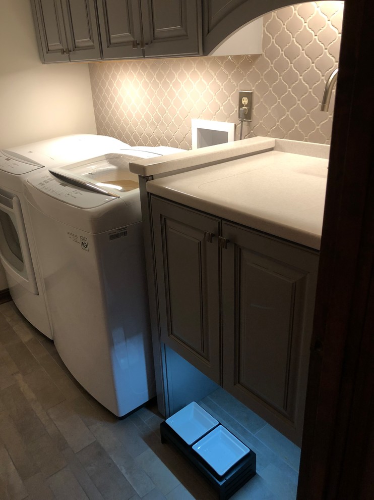 Inspiration for a small transitional galley ceramic tile and gray floor dedicated laundry room remodel in Cincinnati with an undermount sink, raised-panel cabinets, gray cabinets, solid surface countertops and beige walls