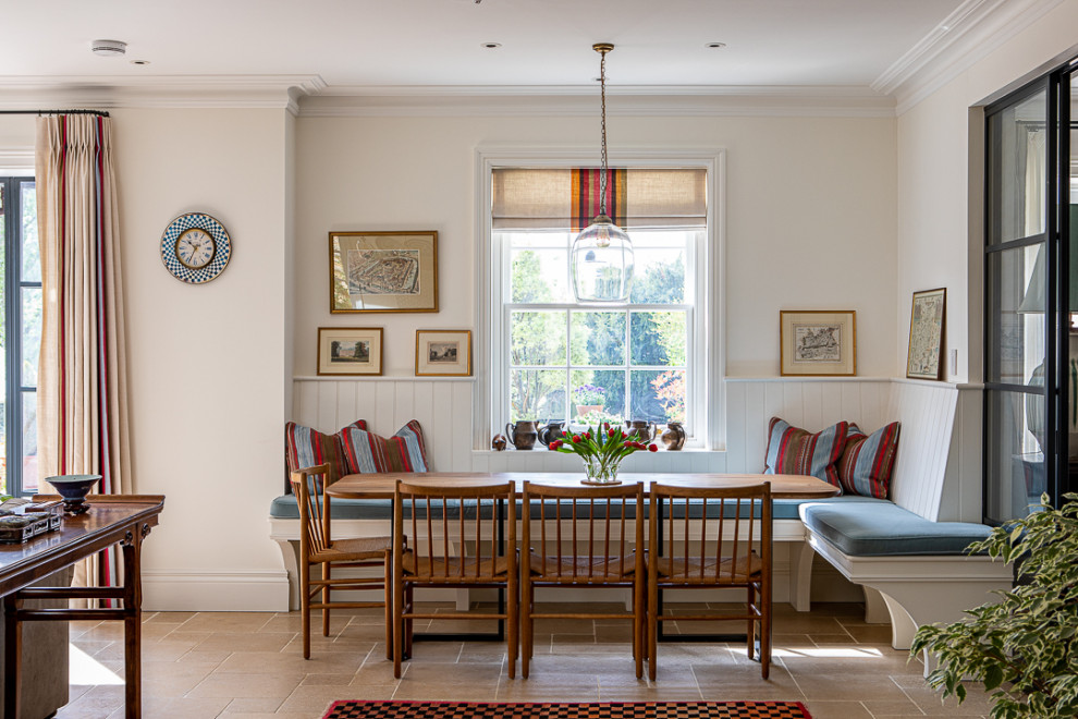 This is an example of a traditional dining room in Dorset with limestone floors, beige floor and beige walls.