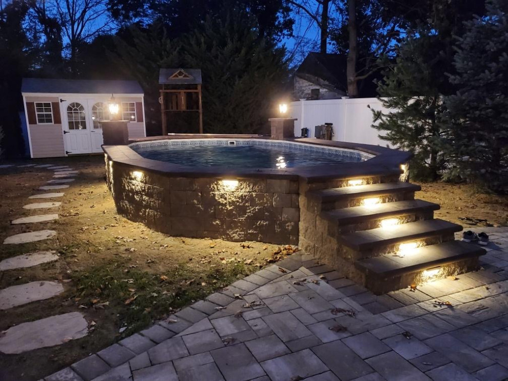 Foto di una grande piscina fuori terra tradizionale personalizzata dietro casa con paesaggistica bordo piscina e pavimentazioni in cemento