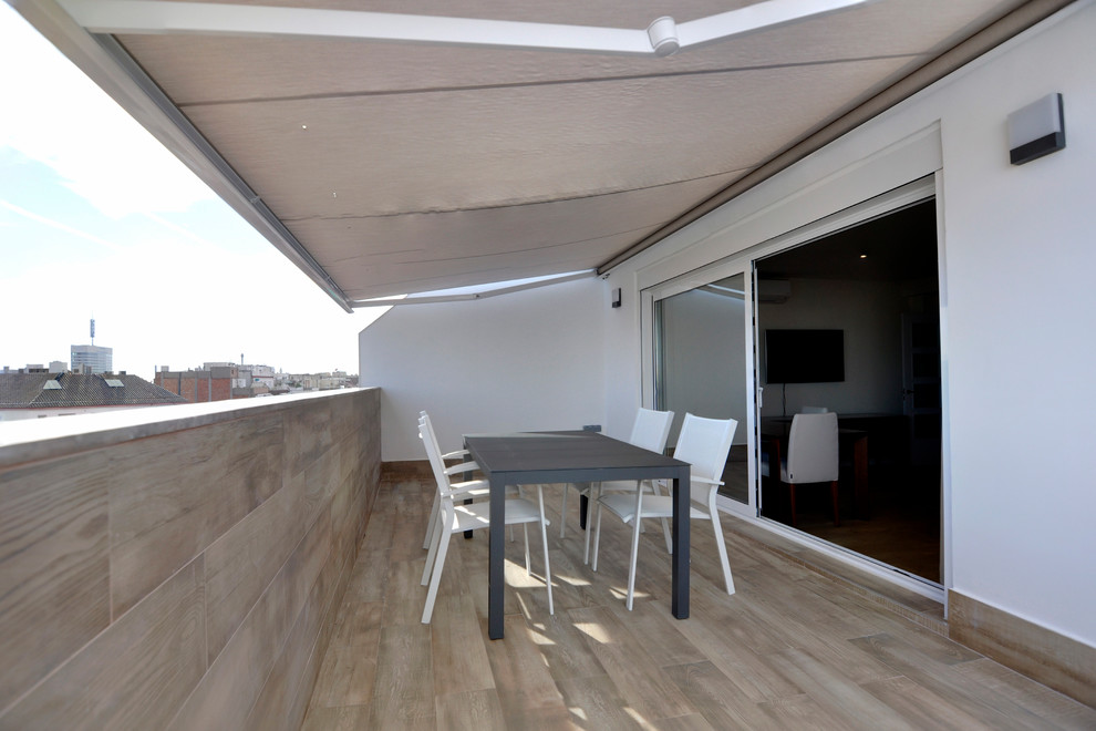 Foto de terraza contemporánea de tamaño medio en patio lateral con toldo