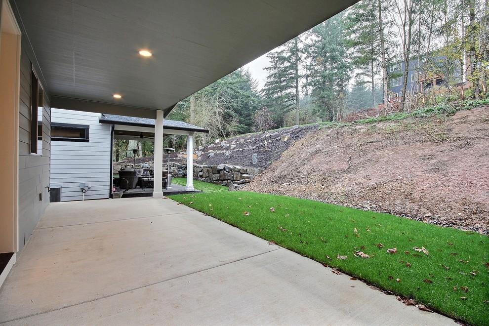 Photo of a large transitional backyard patio in Portland with concrete slab and a roof extension.