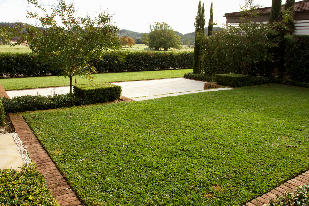 Inspiration for a mediterranean backyard full sun formal garden for spring in Sydney with natural stone pavers.
