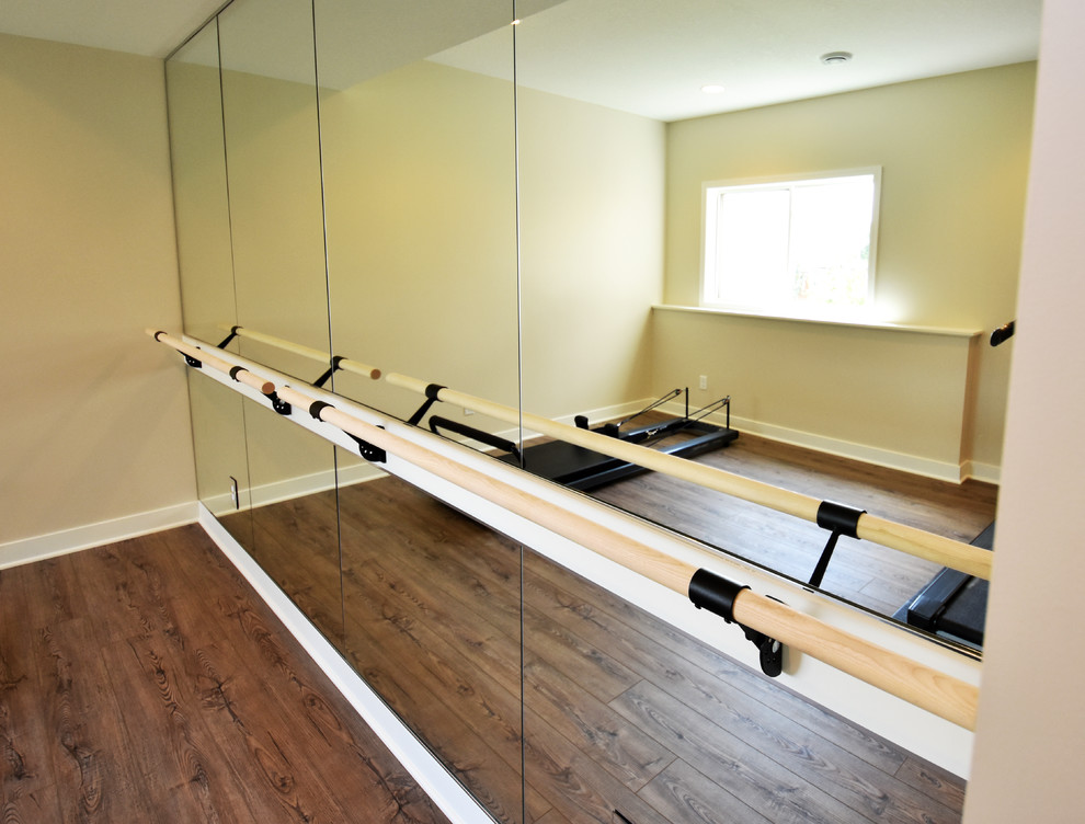 Photo of a large contemporary home gym in Minneapolis with beige walls, vinyl floors and brown floor.