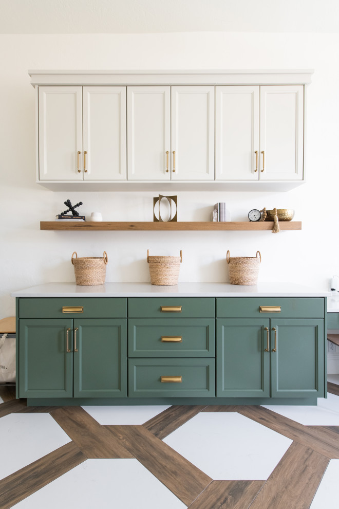 This is an example of a large transitional u-shaped utility room in Salt Lake City with a farmhouse sink, shaker cabinets, green cabinets, quartz benchtops, white walls, porcelain floors, a stacked washer and dryer, white floor, white benchtop and vaulted.