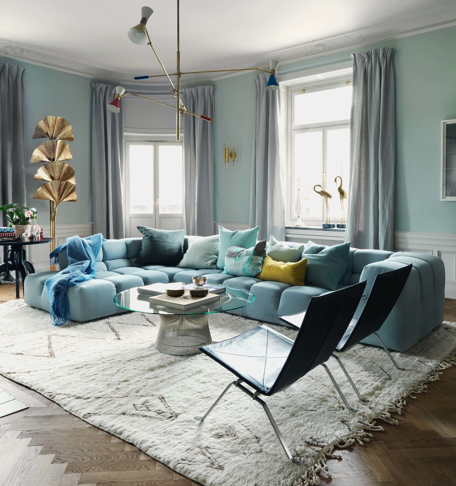Design ideas for an expansive eclectic open concept living room in Stockholm with blue walls and medium hardwood floors.