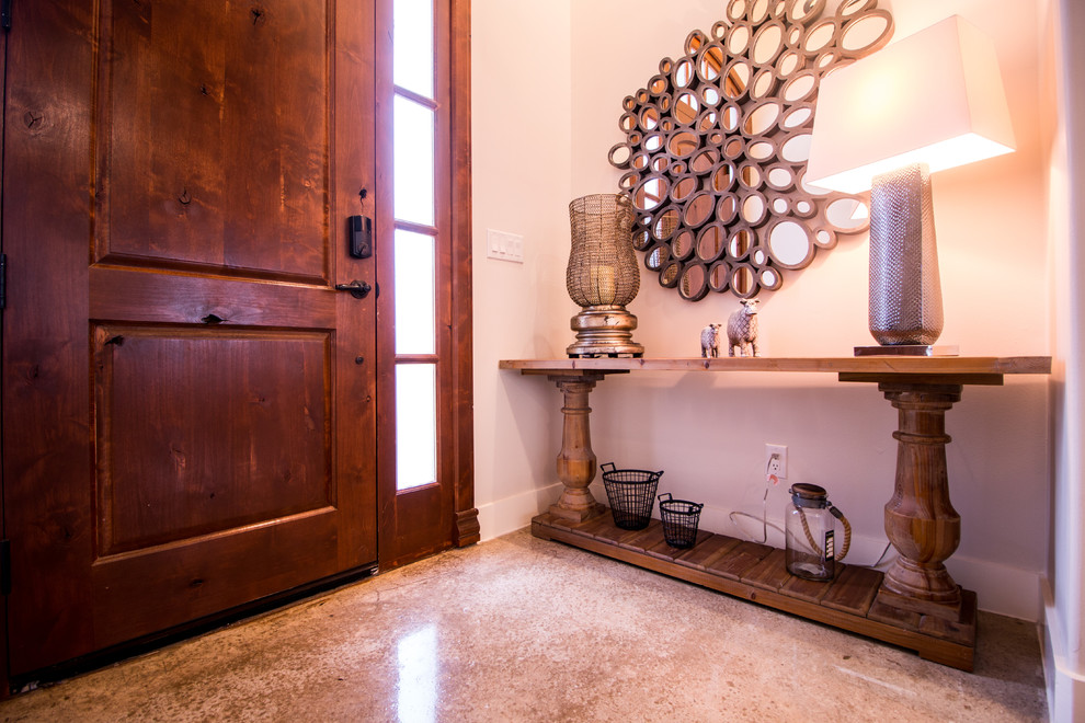 Mid-sized mountain style concrete floor and gray floor foyer photo with beige walls and a medium wood front door