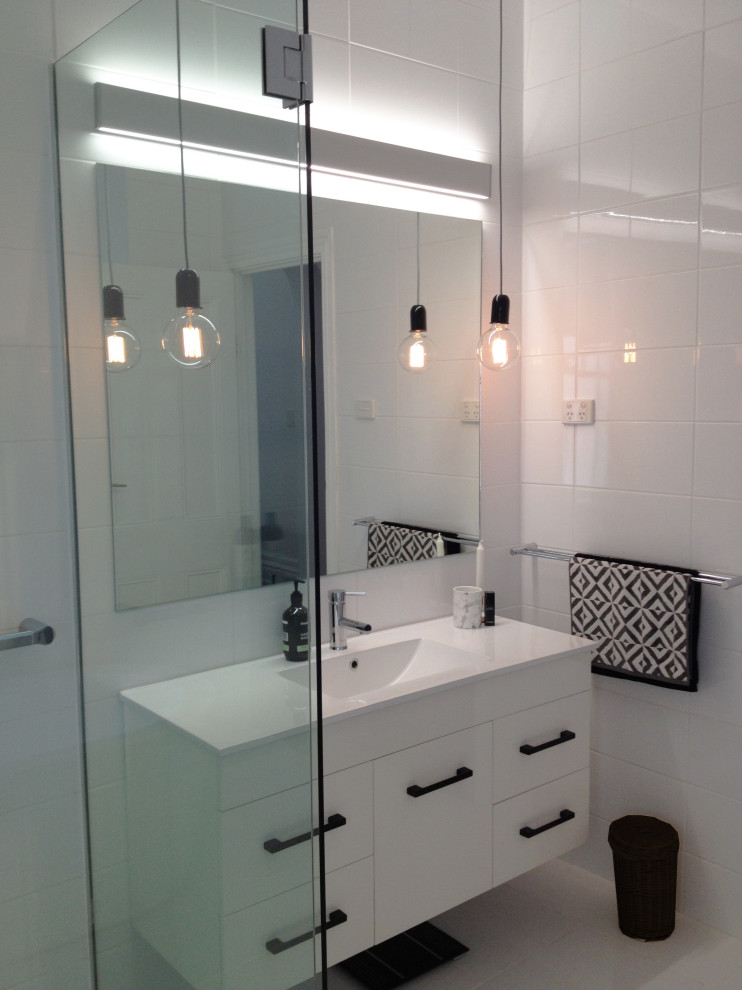 This is an example of a mid-sized scandinavian master bathroom in Perth with white cabinets, a freestanding tub, white walls, an integrated sink, white floor, a hinged shower door, white benchtops, a floating vanity, porcelain tile and porcelain floors.