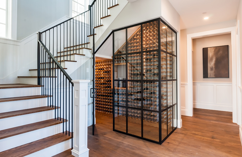 Photo of a mid-sized transitional wine cellar in Los Angeles with medium hardwood floors, storage racks and brown floor.