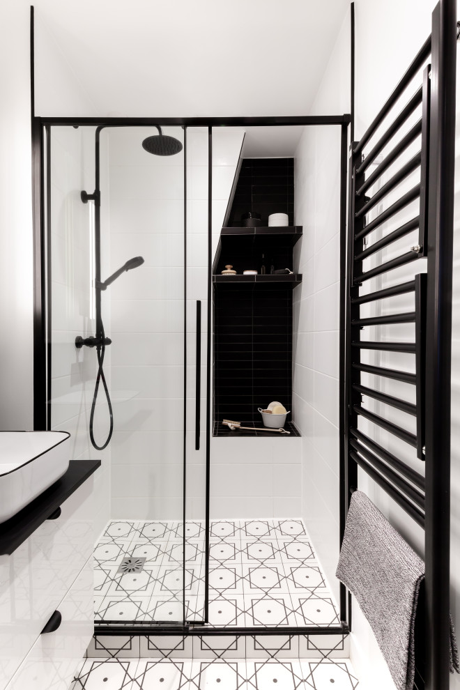 На фото: главная ванная комната среднего размера в стиле модернизм с белыми фасадами, двойным душем, раздельным унитазом, белой плиткой, белыми стенами, полом из керамической плитки, накладной раковиной, белым полом, душем с раздвижными дверями, черной столешницей, тумбой под одну раковину и подвесной тумбой