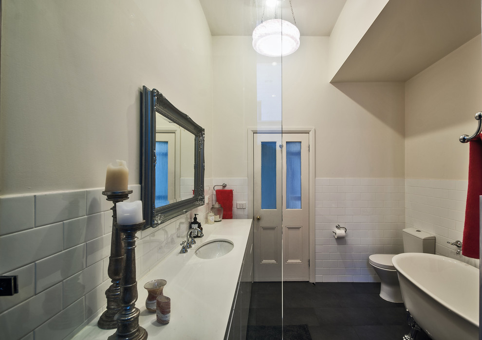 Inspiration for a mid-sized contemporary kids bathroom in Melbourne with flat-panel cabinets, white cabinets, a claw-foot tub, an alcove shower, a one-piece toilet, white tile, ceramic tile, white walls, porcelain floors, an undermount sink, engineered quartz benchtops, grey floor and an open shower.