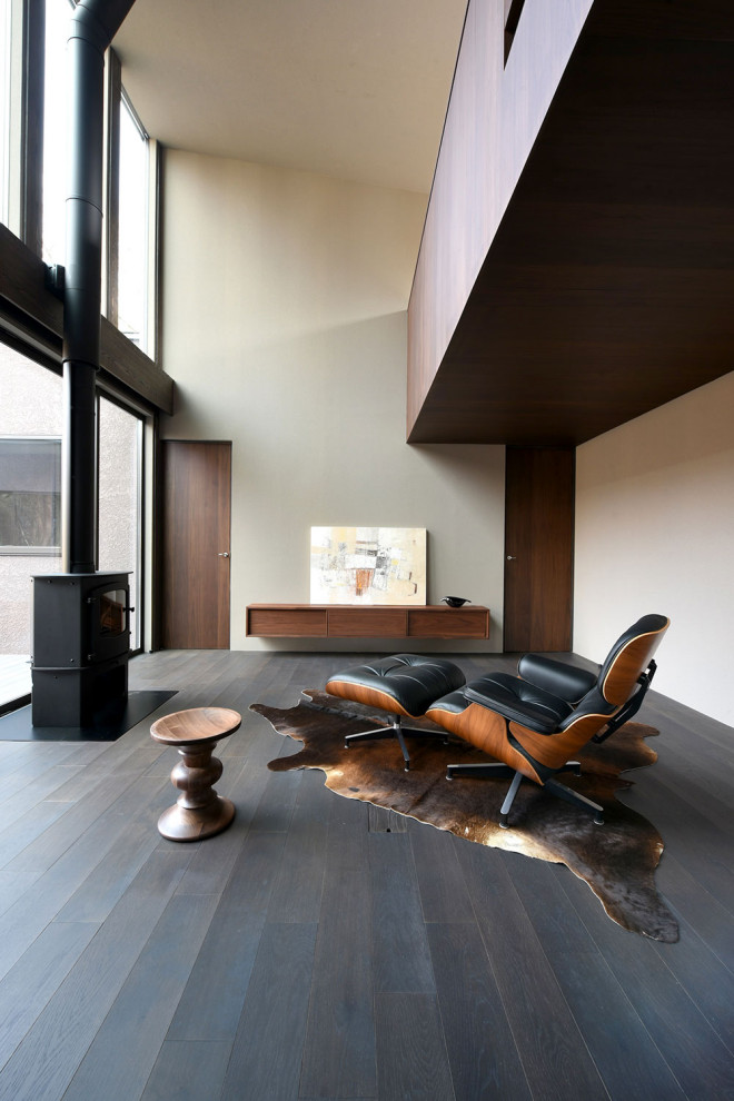Идея дизайна: открытая гостиная комната среднего размера в стиле ретро с серыми стенами, темным паркетным полом, печью-буржуйкой, фасадом камина из металла, телевизором на стене, черным полом и деревянными стенами
