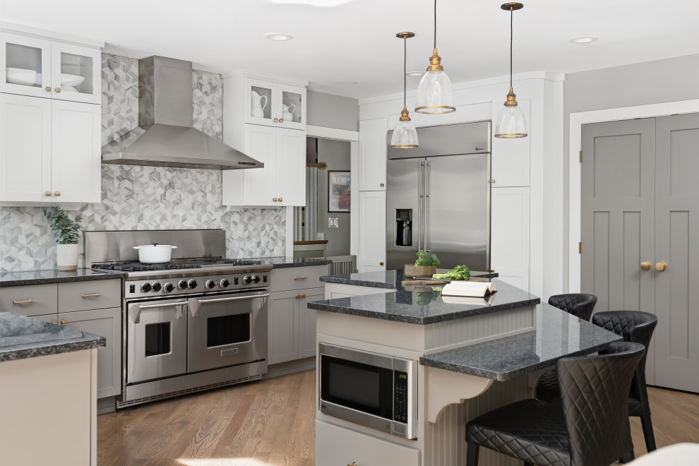 Kitchen - large transitional medium tone wood floor and brown floor kitchen idea in Chicago with shaker cabinets, granite countertops, gray backsplash, marble backsplash, stainless steel appliances, an island, black countertops and gray cabinets