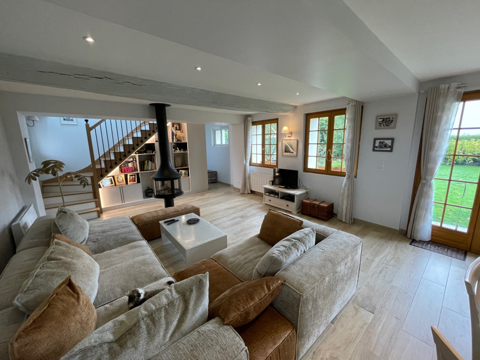 Esempio di un ampio soggiorno country con pareti beige, pavimento con piastrelle in ceramica, stufa a legna e pavimento beige