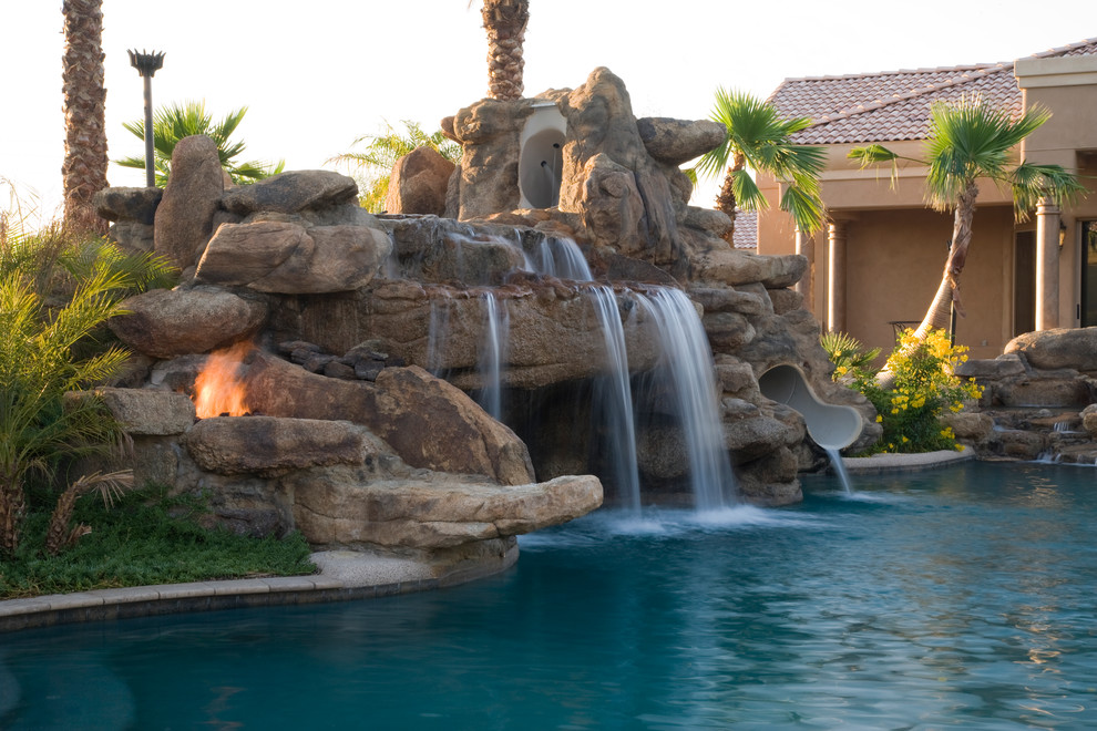 Photo of a tropical pool in Phoenix with a water slide.