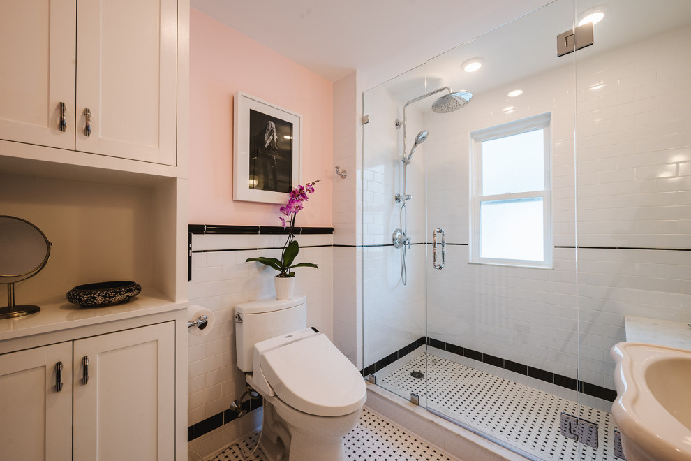 Cette image montre une petite salle de bain principale victorienne avec une douche ouverte, un bidet, un carrelage noir et blanc, un carrelage métro, un mur rose, un sol en carrelage de porcelaine, un lavabo de ferme, une cabine de douche à porte battante et un banc de douche.