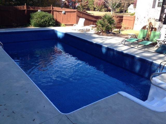 Inspiration for a backyard stamped concrete and rectangular pool remodel