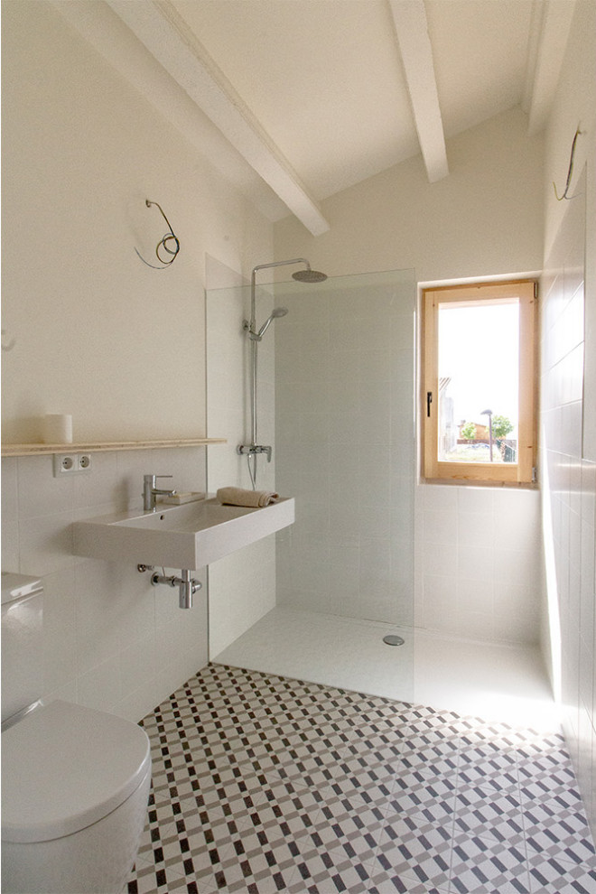 Design ideas for a mid-sized contemporary 3/4 bathroom in Other with a wall-mount toilet, white tile, white walls, a wall-mount sink, multi-coloured floor and a single vanity.