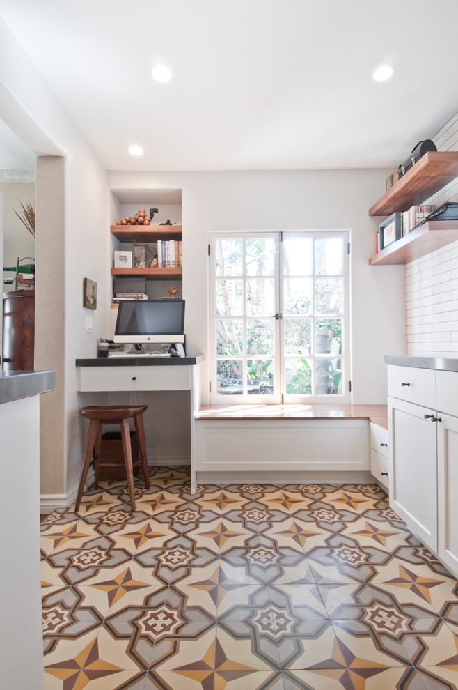 Photo of a mid-sized transitional galley open plan kitchen in Los Angeles with an undermount sink, shaker cabinets, white cabinets, quartzite benchtops, white splashback, ceramic splashback, stainless steel appliances, cement tiles, with island and multi-coloured floor.