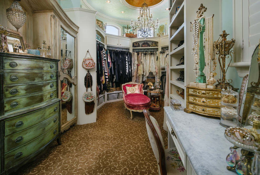 This is an example of a large traditional women's walk-in wardrobe in Houston with white cabinets, carpet and open cabinets.