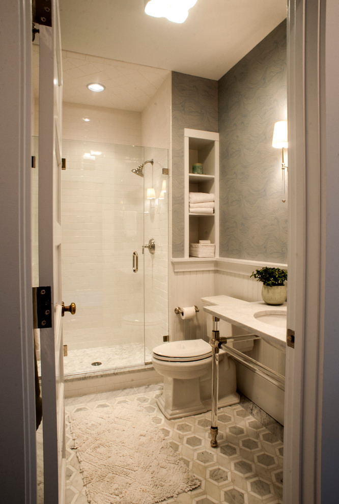 Inspiration for a mid-sized beach style 3/4 bathroom in Portland Maine with an alcove shower, a two-piece toilet, blue walls, mosaic tile floors, an undermount sink, marble benchtops, grey floor and a hinged shower door.