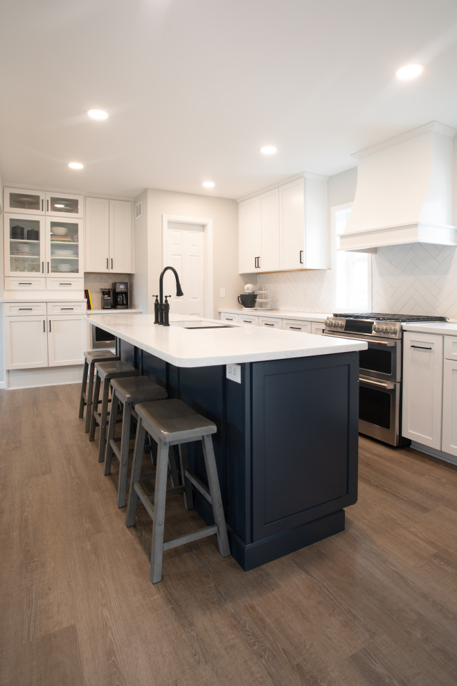 Kitchen - transitional vinyl floor kitchen idea with shaker cabinets, white cabinets, quartz countertops, white backsplash, porcelain backsplash, stainless steel appliances and white countertops