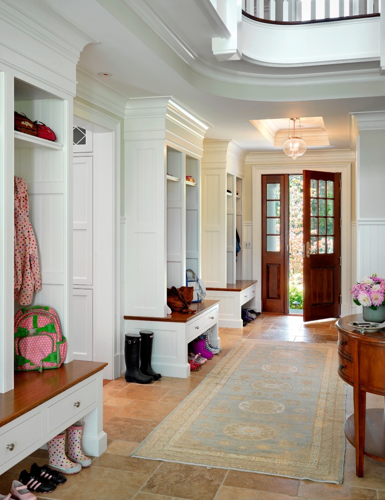 Photo of a large traditional mudroom in Boston with white walls and a dark wood front door.