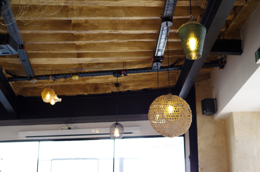 На фото: столовая в стиле лофт с светлым паркетным полом и балками на потолке