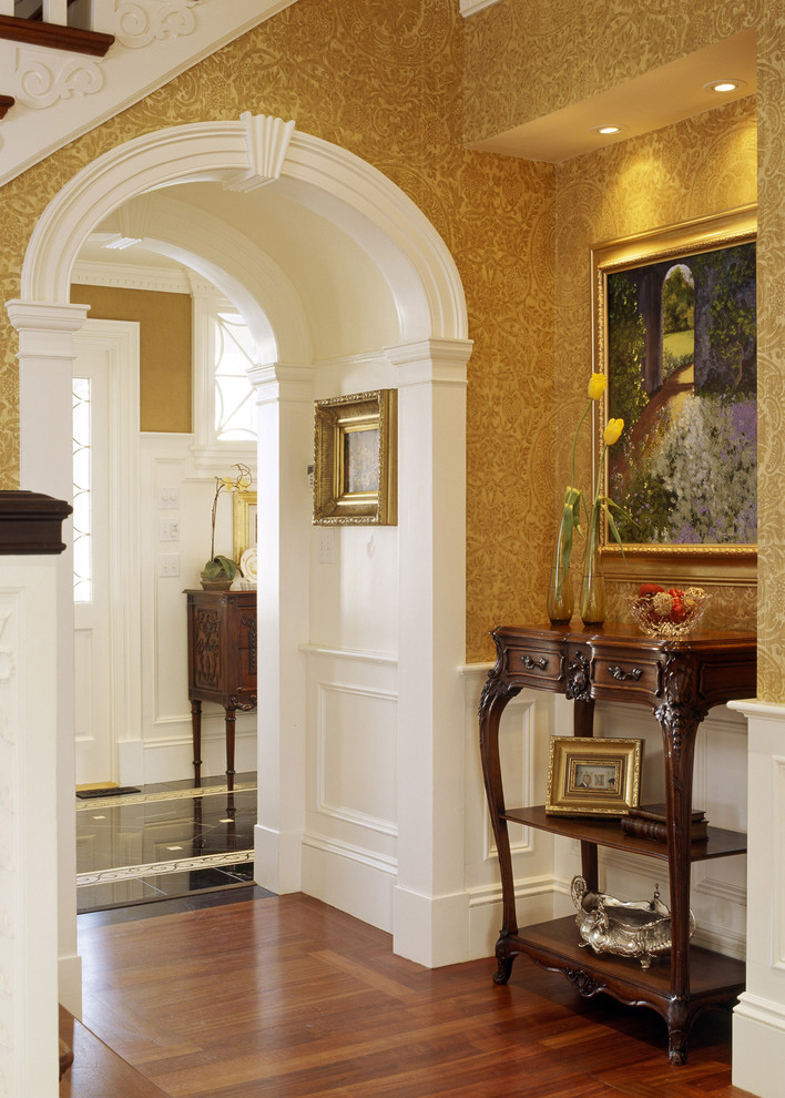 This is an example of a traditional entryway in Boston with yellow walls and medium hardwood floors.