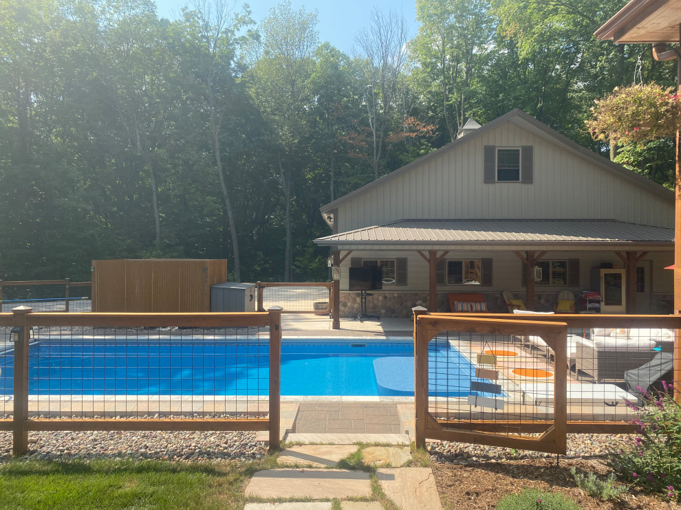 This is an example of a large country side yard rectangular pool in Milwaukee with with a pool and concrete pavers.