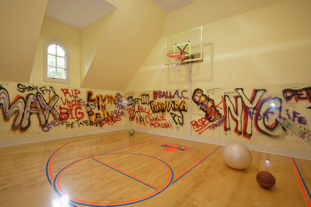 Expansive contemporary indoor sport court in New York with beige walls, light hardwood floors and vaulted.