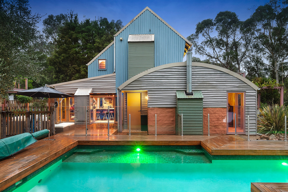 Photo of a beach style three-storey blue exterior in Melbourne with wood siding and a gable roof.