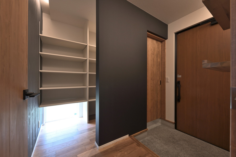 This is an example of a modern entryway in Other with black walls, dark hardwood floors, a dutch front door, a brown front door and beige floor.