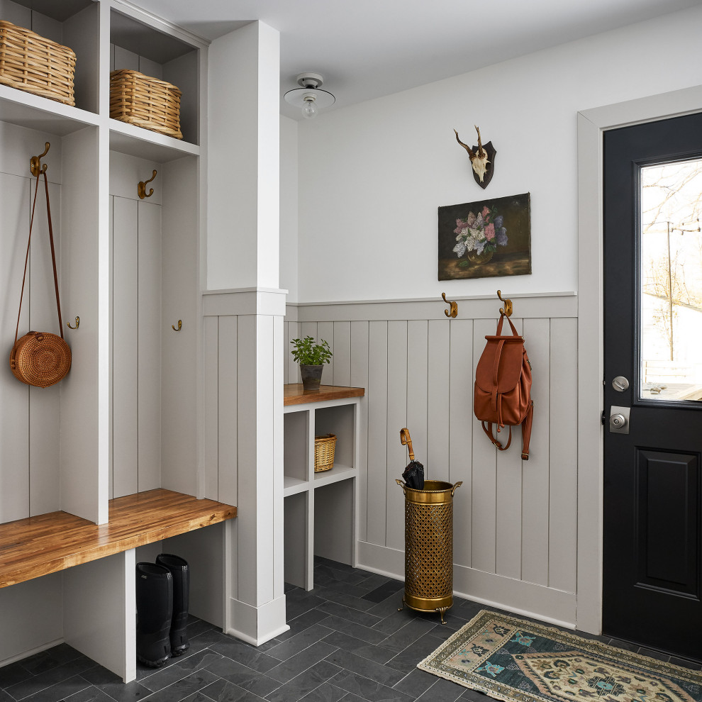 Large rural entrance in Chicago with multi-coloured walls, slate flooring, black floors and wainscoting.