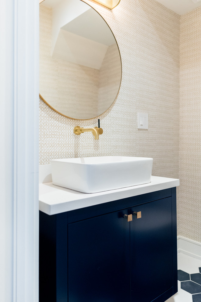 This is an example of a transitional powder room in Toronto with recessed-panel cabinets, a one-piece toilet, cement tiles, a vessel sink, engineered quartz benchtops, white benchtops, a floating vanity and wallpaper.