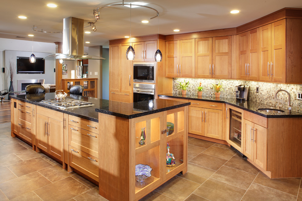 This is an example of a large contemporary galley open plan kitchen in Sacramento with shaker cabinets, light wood cabinets, multi-coloured splashback, mosaic tile splashback, granite benchtops, stainless steel appliances, with island, concrete floors and a farmhouse sink.