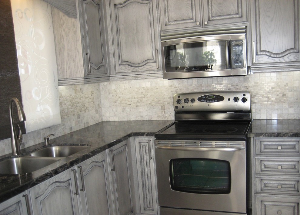 Photo of a traditional kitchen in Toronto with a double-bowl sink, beaded inset cabinets, grey cabinets, granite benchtops, white splashback and stainless steel appliances.