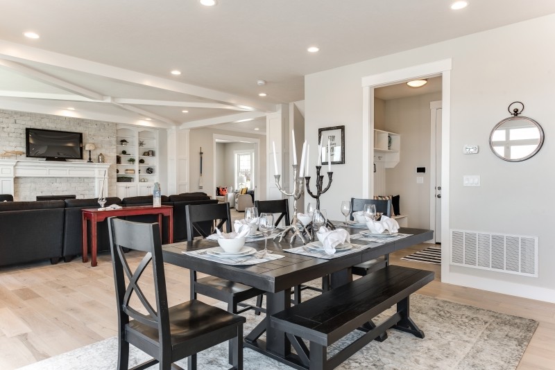 Mid-sized beach style open plan dining in Salt Lake City with grey walls, light hardwood floors, a standard fireplace and beige floor.