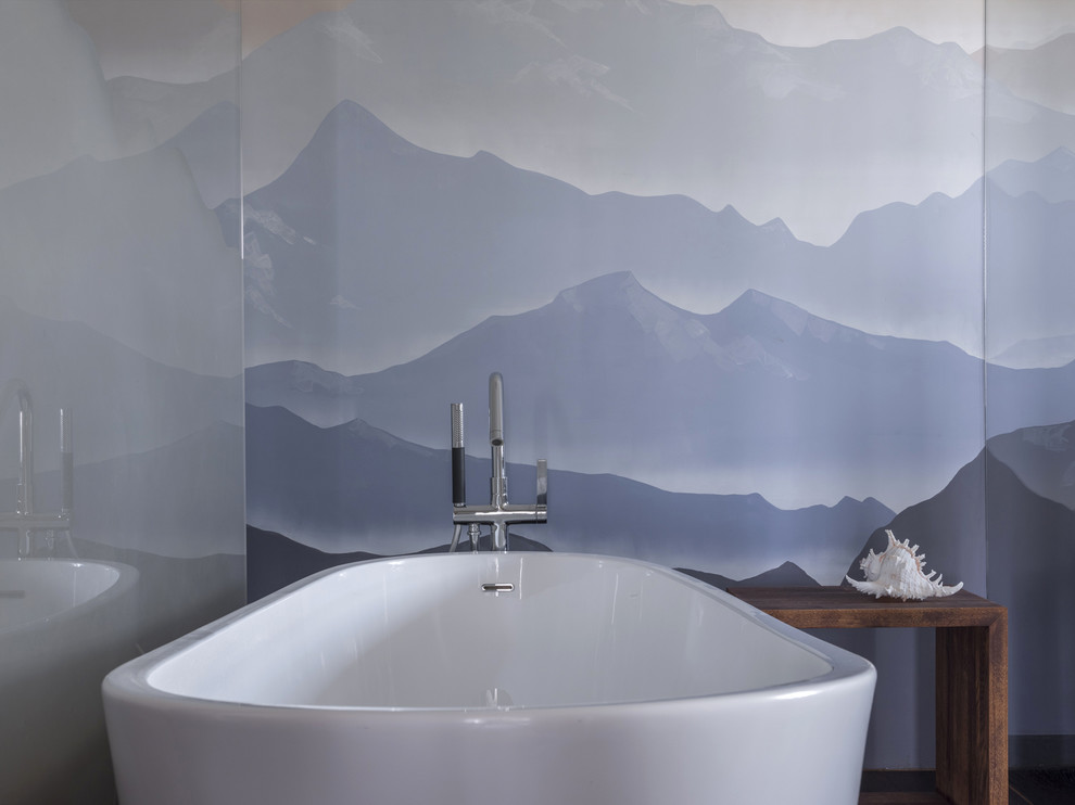 Imagen de cuarto de baño de tamaño medio con bañera exenta, sanitario de pared, baldosas y/o azulejos de porcelana, paredes beige, suelo de madera pintada y suelo marrón